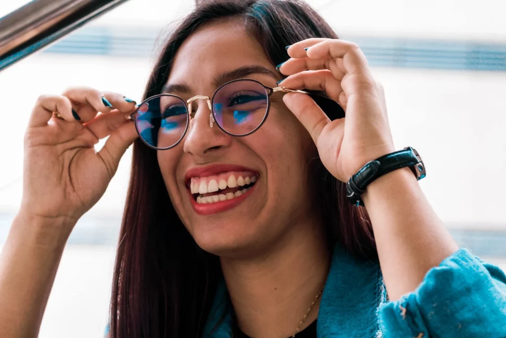 Smiling girl adjusting her glasses