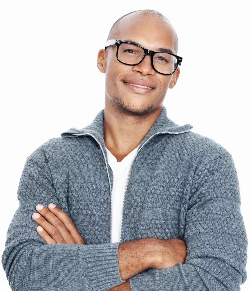 A guy wearing eyeglasses is posing with his arms crossed